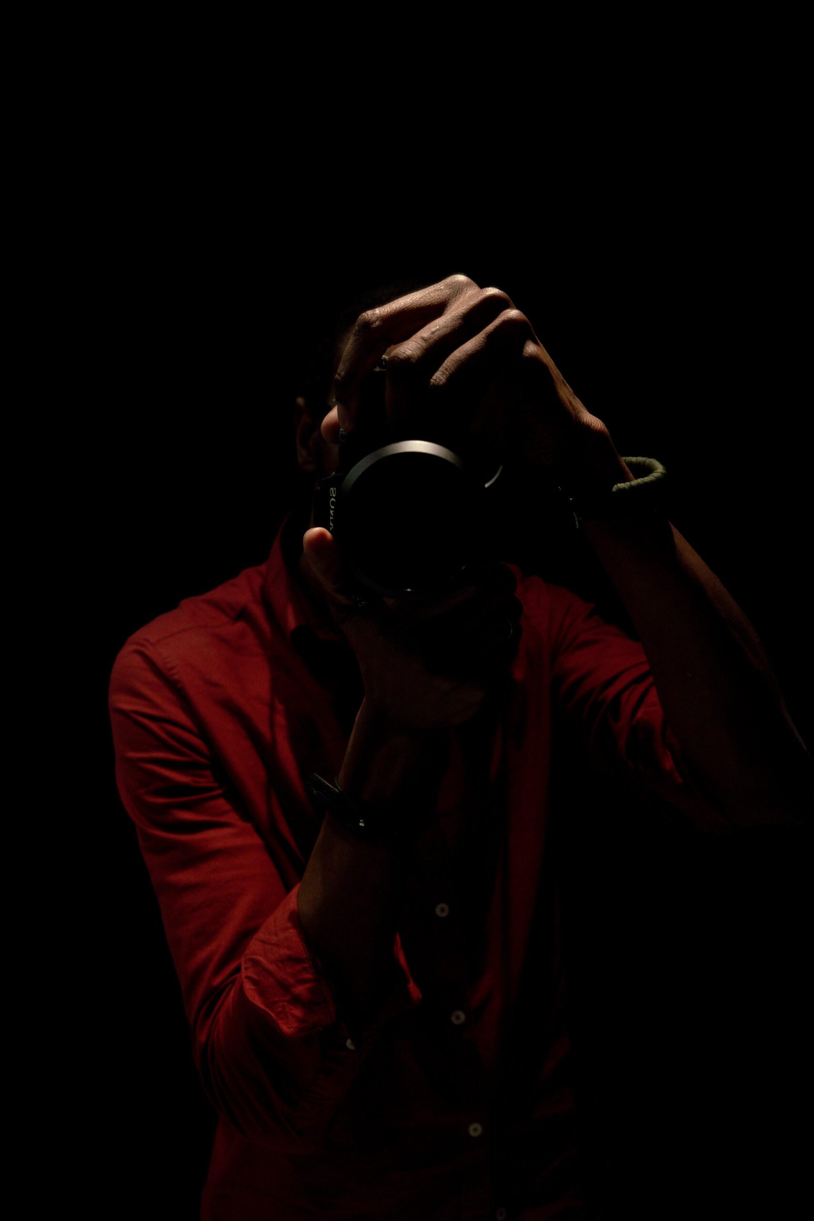 Tendai holding a camera in low light