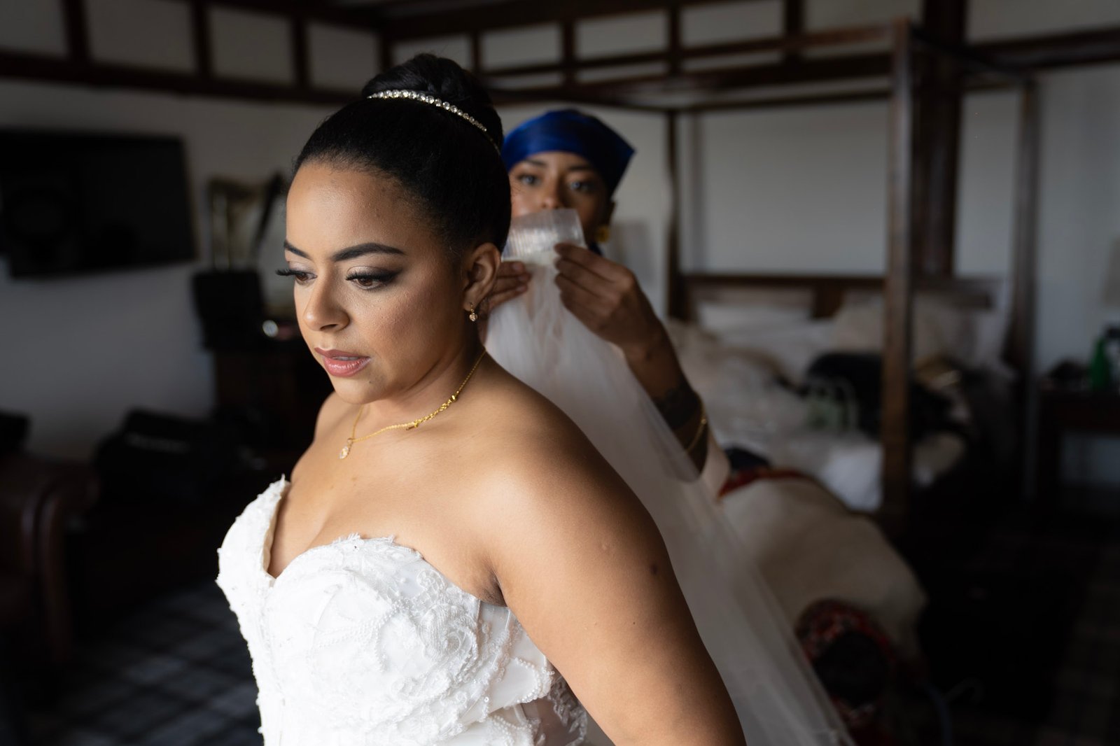 A bride having her veil arranged before the ceremony