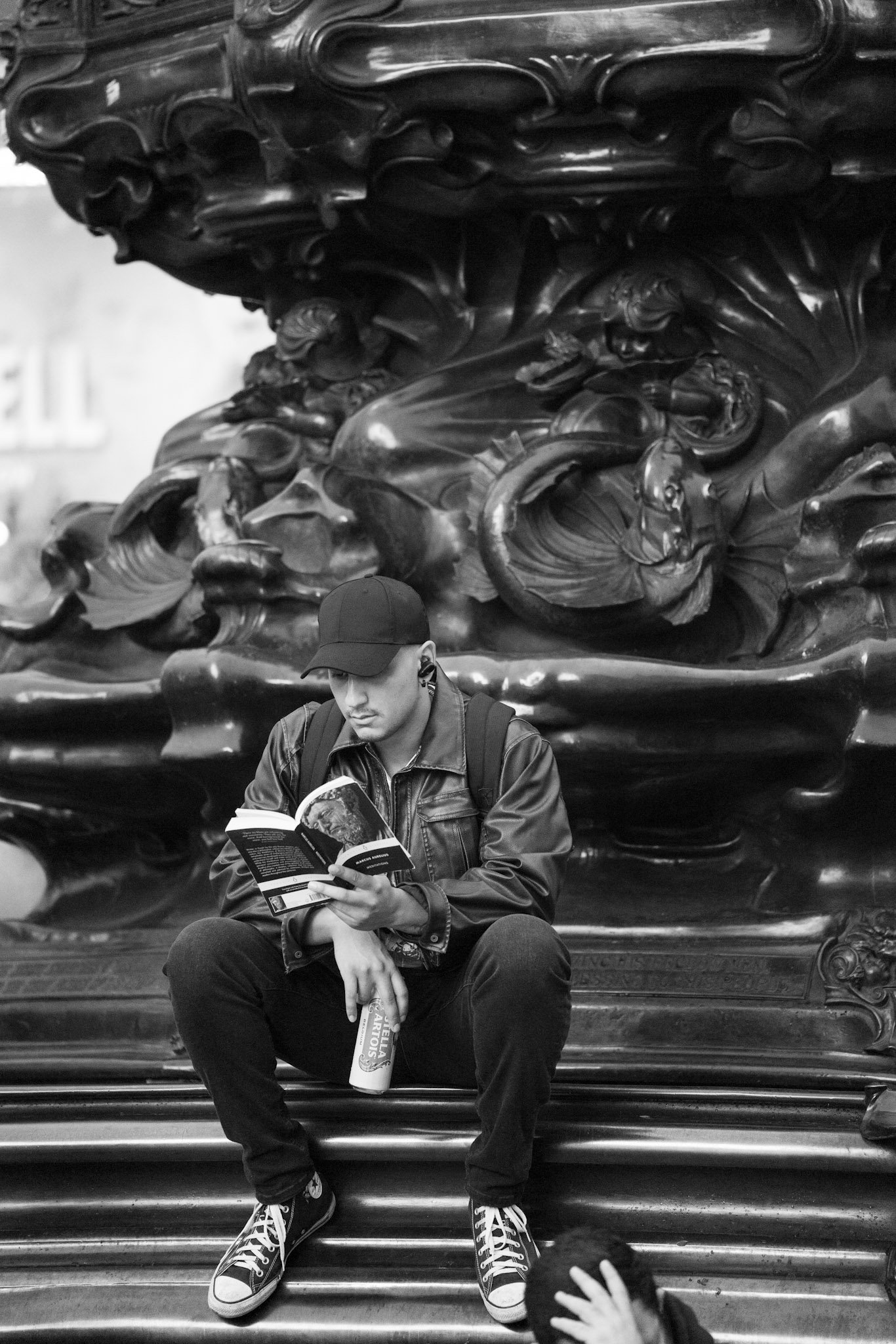 Person sitting beneath a decorative fountain sculpture