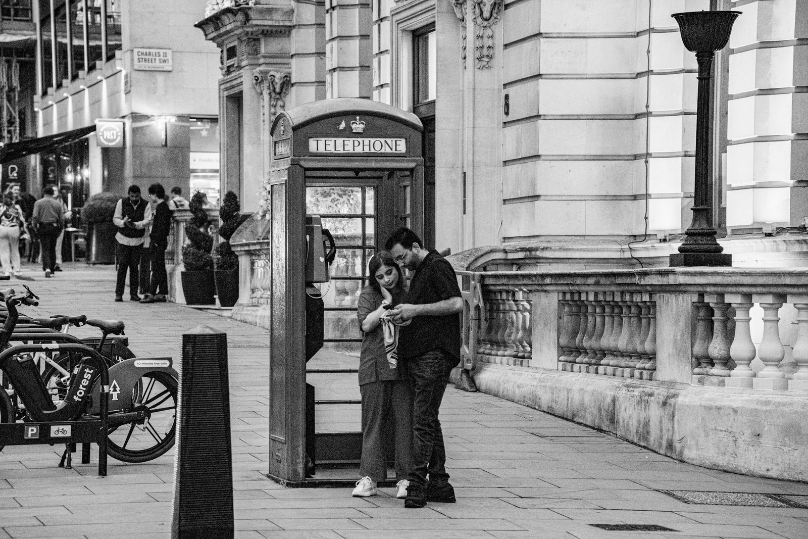 Couple embracing beside a London telephone box