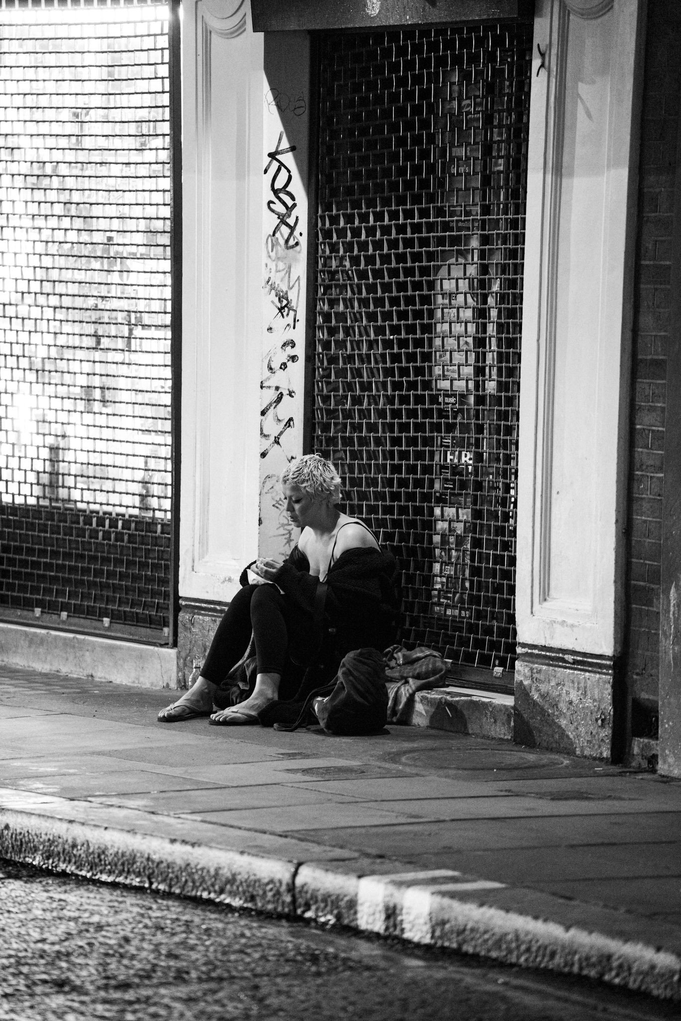 Person seated in a doorway beside the street