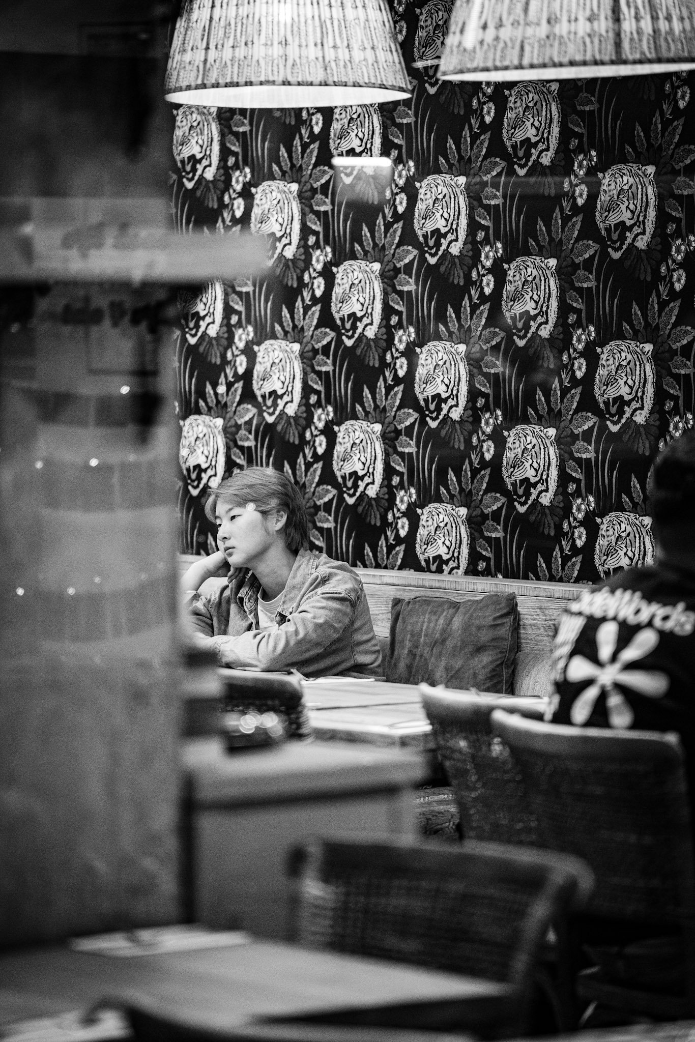 Woman seated inside a cafe seen through the window