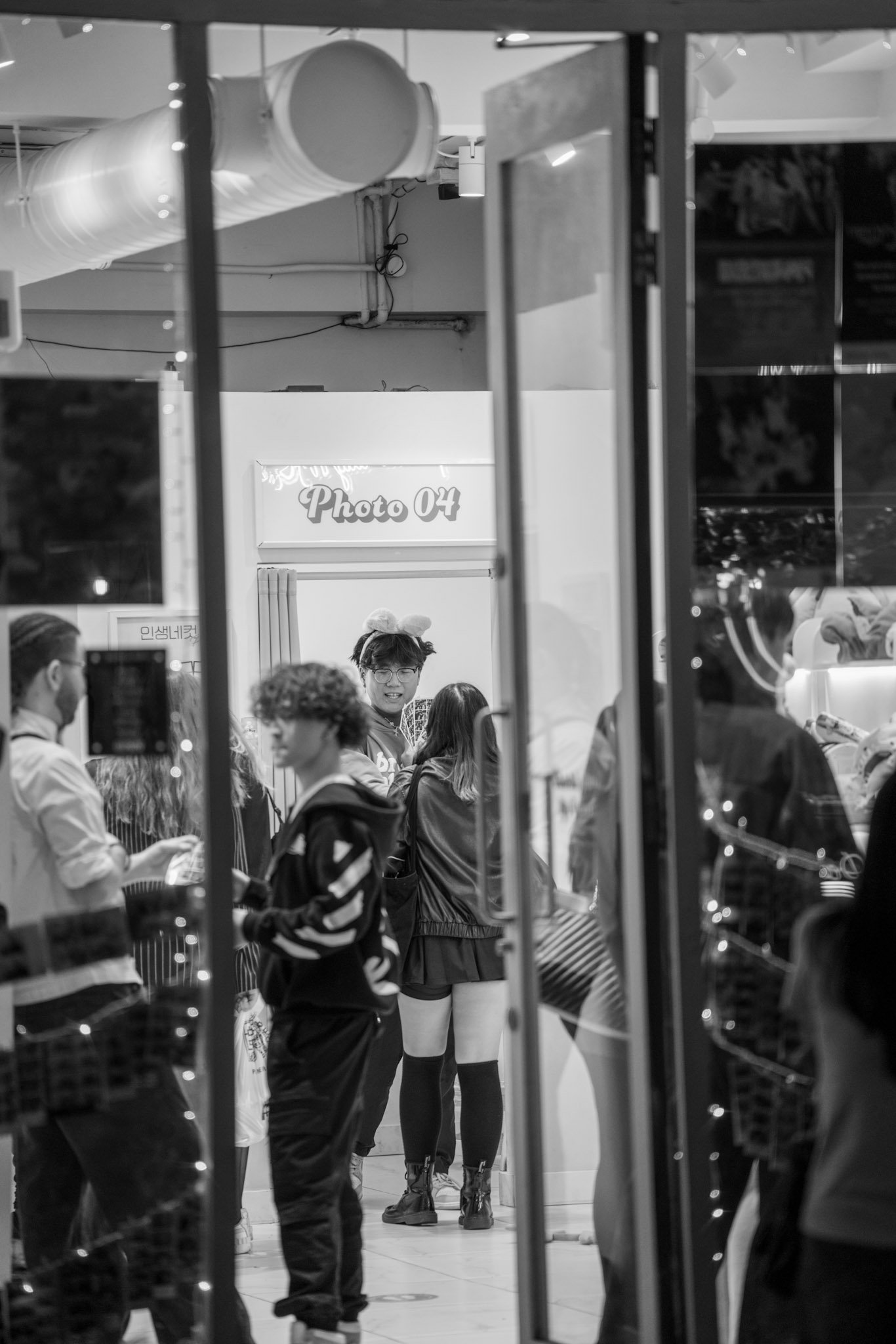 Barber and customer seen through a reflective shop window