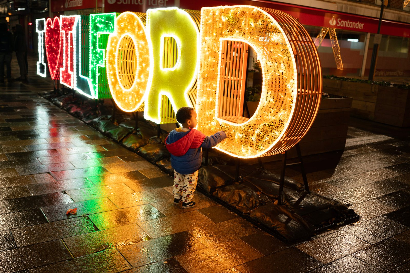 Child standing in front of an illuminated word sign