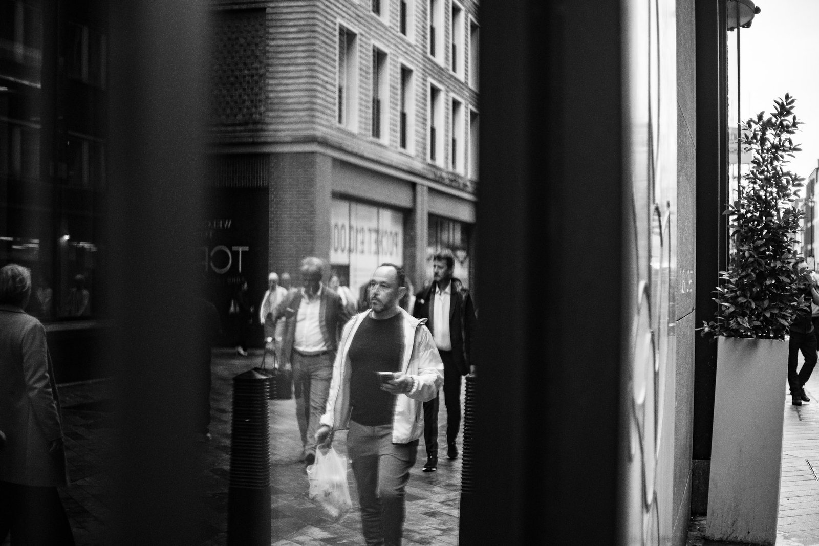 Pedestrians reflected in a city shop window