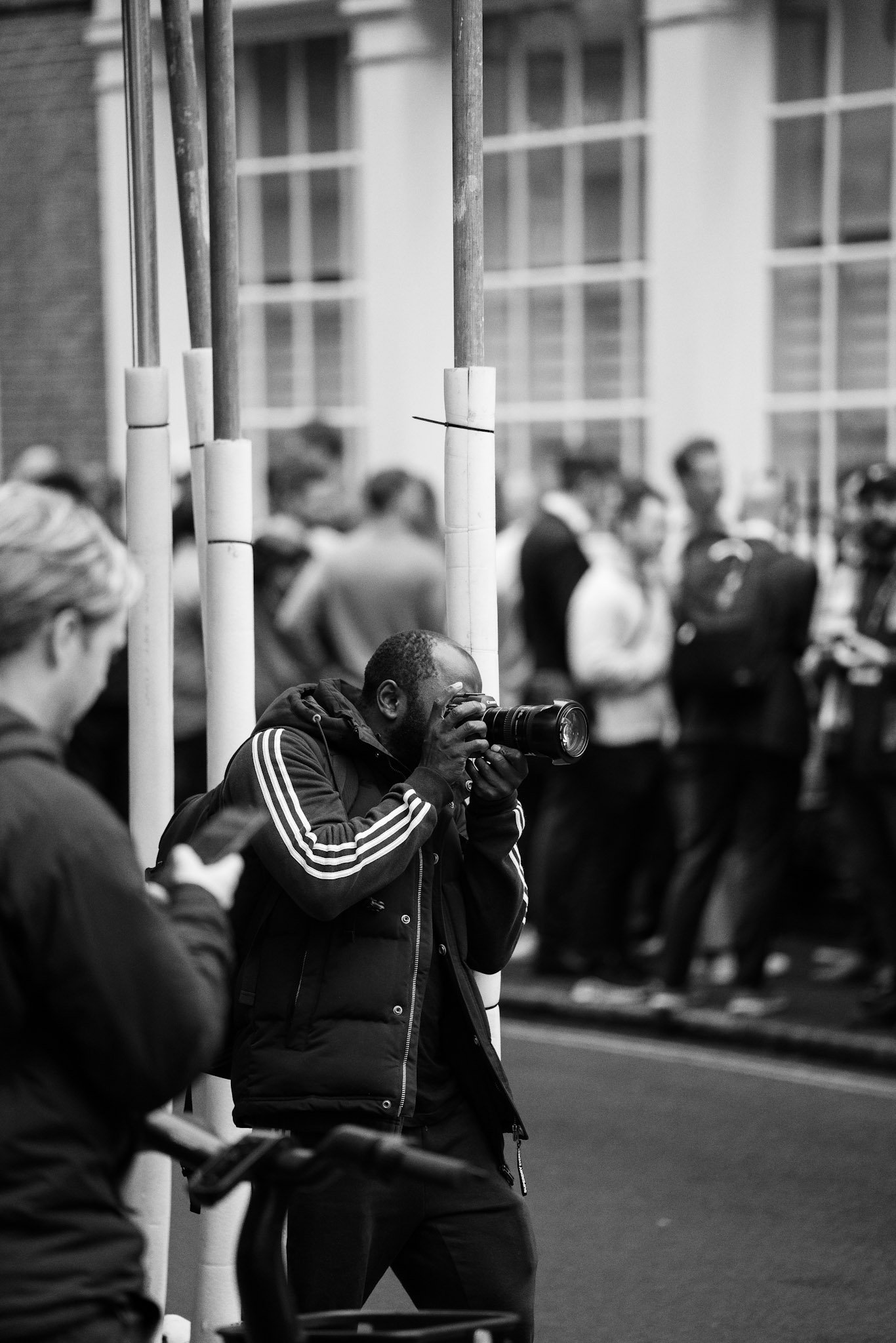 Woman in a sports jacket watching a city crowd