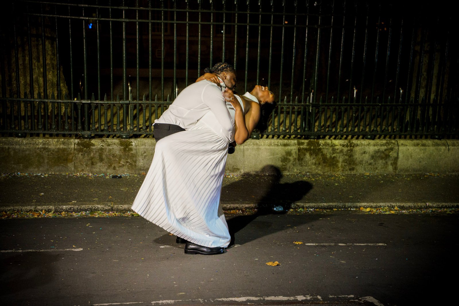 Bride and groom embracing beneath a streetlight